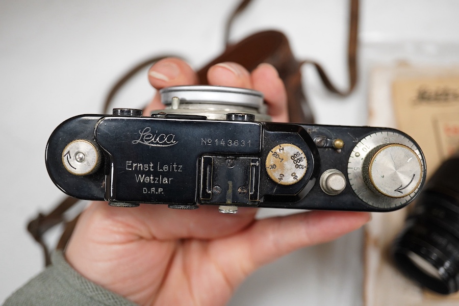 A Leica Model II camera in leather case, together with an Elmar 4.5/135mm lens, lens table booklet and instruction booklet. Condition - poor to fair.